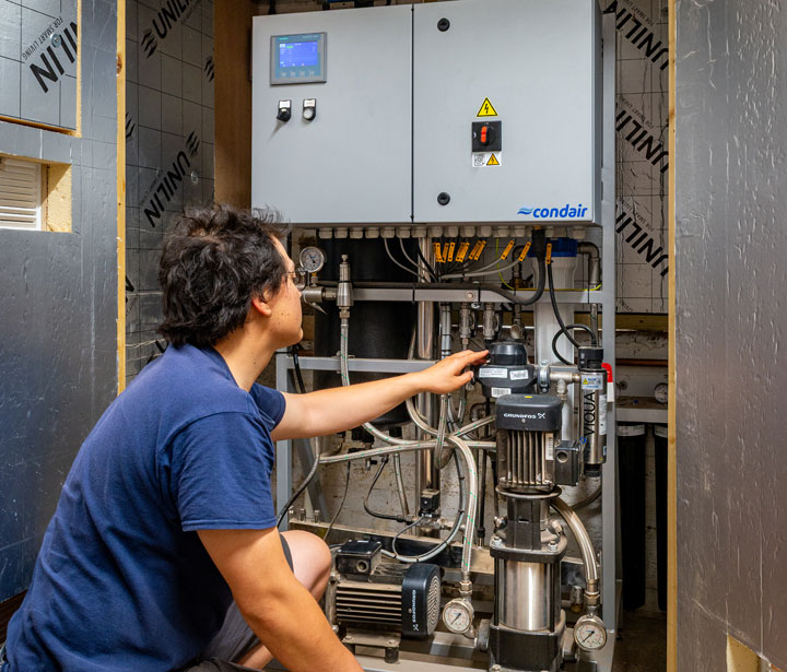 A water treatment system both purifies and pressurises mains water, supplying it to a series of nozzles located around the greenhouse.